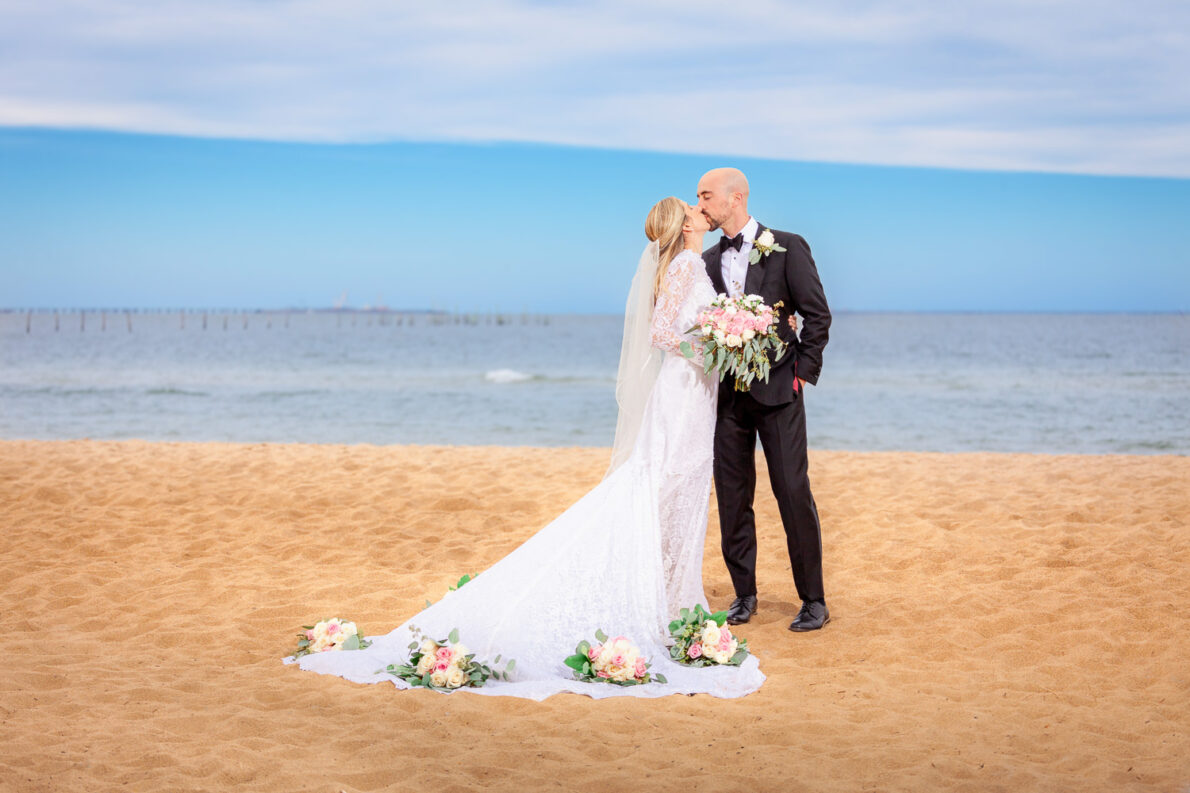Bride and groom holding hands on a sandy beach, a perfect moment from Ryan Clark Photography’s wedding packages.