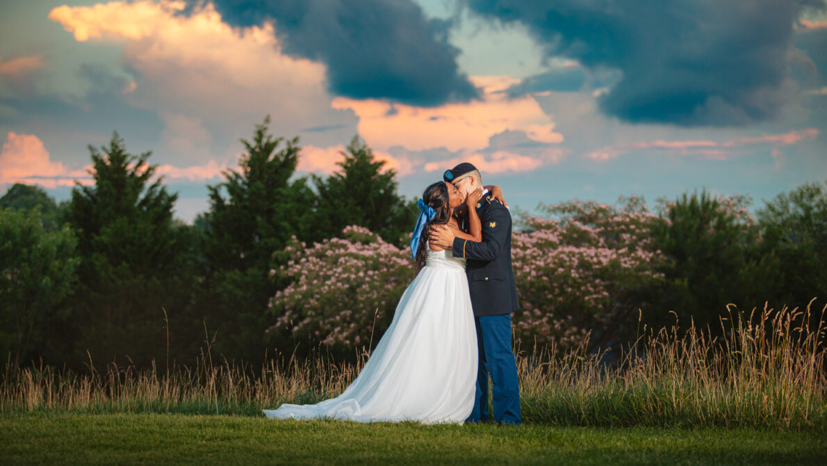 Bride and groom embracing under a dramatic sunset sky, part of Ryan Clark Photography's wedding packages.